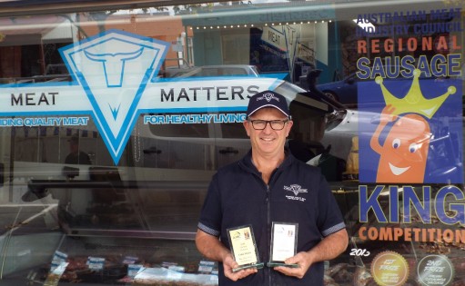 Mal, in front of the Meat Matters shop, holding his awards.